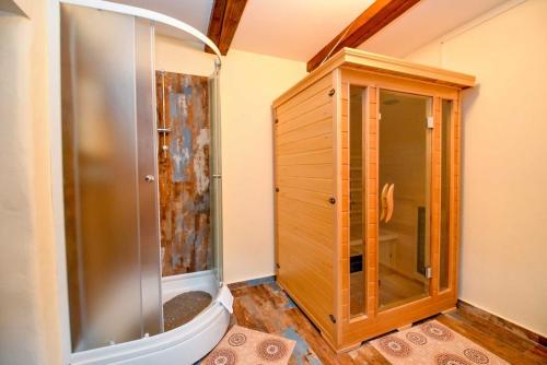 La salle de bains est pourvue d'une douche et d'une armoire en bois. dans l'établissement Hiža Golubić, à Vinica