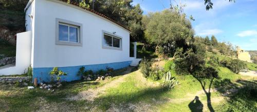 a small white house with a window on the side of it at Paradise House Over the Sea in Sesimbra