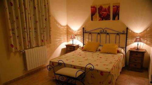 1 dormitorio con 1 cama y 2 mesitas de noche con lámparas en Casa Rural El Rubial, en Cehegín