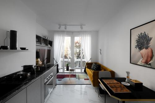 uma cozinha e sala de estar com um sofá amarelo em Aria Boutique Apartments Farneti em Milão