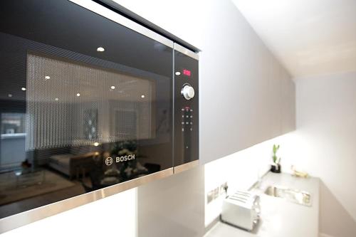 a kitchen with a microwave oven and a sink at Foundry luxury new one bedroom apartments close to town center in Luton