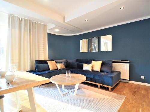 a living room with a blue couch and a table at VIP Apartamenty Stara Polana in Zakopane