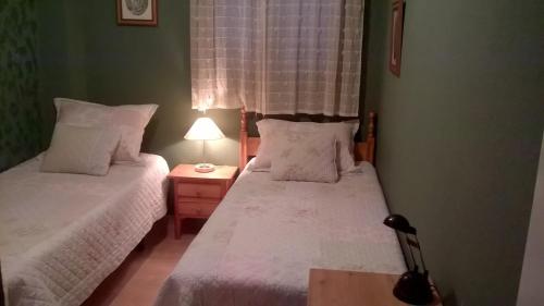 um quarto com duas camas e um candeeiro sobre uma mesa em 30A MONANTERRA Atlanterra Urbanización Mar de Plata em Zahara de los Atunes