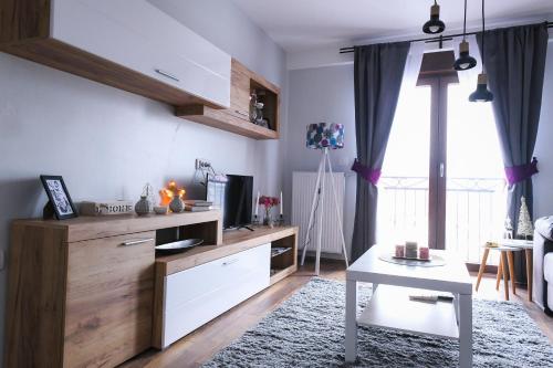 a living room with a table and a kitchen at Apartman Filip in Novi Pazar