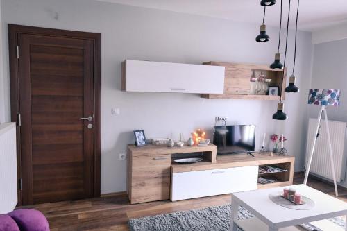 a living room with a wooden entertainment center with a television at Apartman Filip in Novi Pazar
