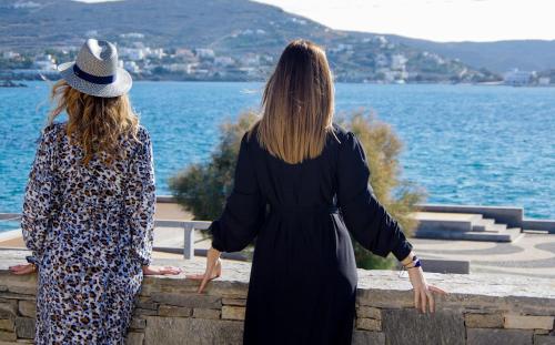 two women standing on a wall looking at the water at Syros Wellness Luxury Suites in Finikas