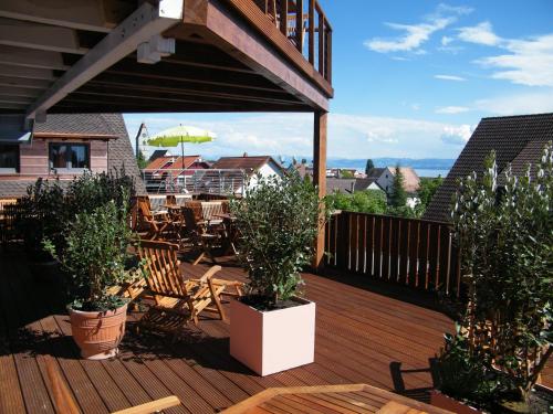 a wooden deck with potted plants on a patio at BnB Fliegerhaeusle Hagnau 24h Self Check In in Hagnau