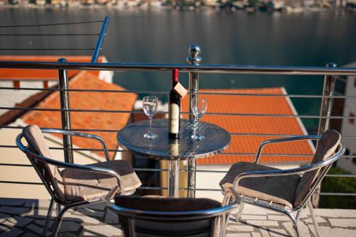 a table with two glasses and a bottle of wine at Apartments Marković in Kotor