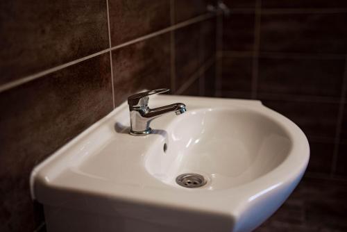 a white bathroom sink with a faucet on a wall at Apartments Marković in Kotor