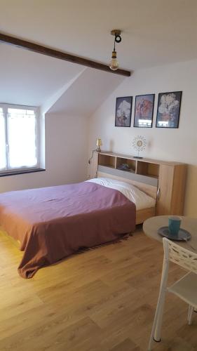 une chambre avec un grand lit et une table dans l'établissement Studios tout équipés, à Cosne-Cours-sur-Loire