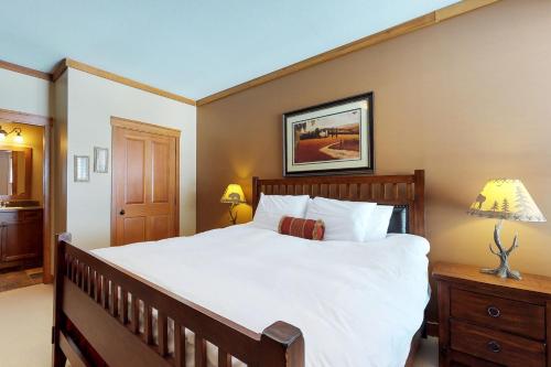 a bedroom with a large bed with white sheets at Snowbirds in Big White