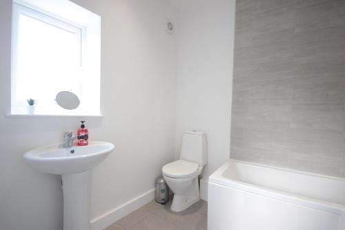 a white bathroom with a toilet and a sink at Studio 332 in Hull