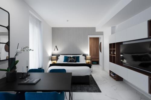 a bedroom with a bed and a desk and a tv at Aria Boutique Apartments Farneti in Milan
