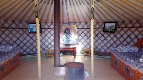 een yurt met 2 bedden en een stoel erin bij orkhon camp in Burgaasatayn Hiid