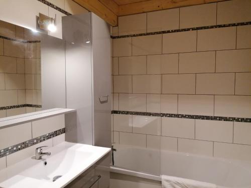 a white bathroom with a sink and a shower at La ferme de lucien in Sallenôves