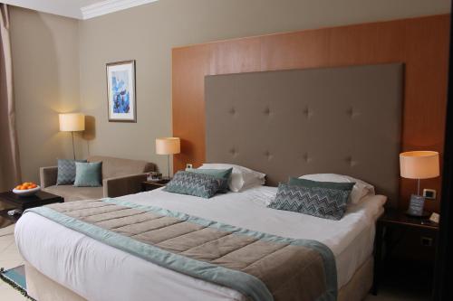 a hotel room with a large bed and a couch at Royal Thalassa Monastir in Monastir