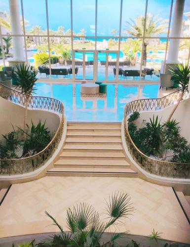 a swimming pool with stairs and plants in a building at Royal Thalassa Monastir in Monastir