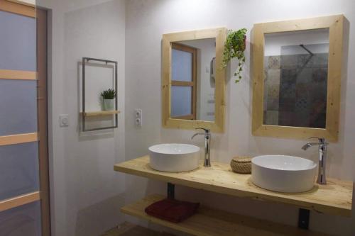 un bagno con due lavandini e due specchi di Bienvenue chez Philippe et Pascale a Villedieu-les-Poëles