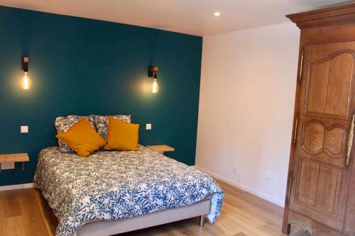 a bedroom with a bed and a blue wall at Bienvenue chez Philippe et Pascale in Villedieu-les-Poëles