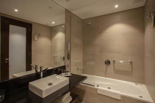 y baño con lavabo, bañera y aseo. en Puerto Norte Design Hotel en Rosario
