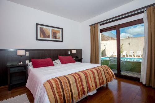 una camera da letto con un letto e una grande finestra di Hotel Roble Blanco a Chascomús
