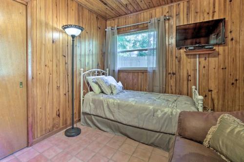 a bedroom with a bed and a tv and a couch at Rainbow River Oasis with Kayaks and Furnished Sunroom! in Dunnellon