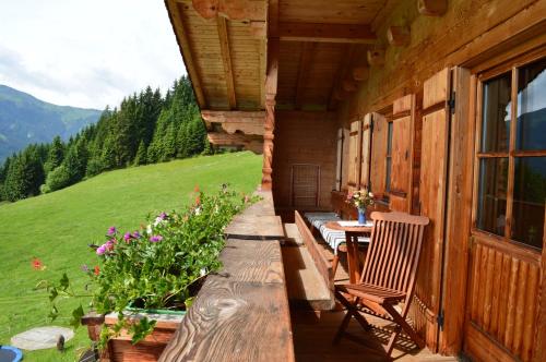 a porch of a cabin with a table and chairs at Biobauernhof Fleckl in Hopfgarten im Brixental