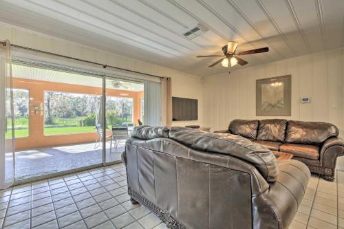 a living room with two leather couches and a ceiling fan at Rainbow River Oasis with Kayaks and Furnished Sunroom! in Dunnellon