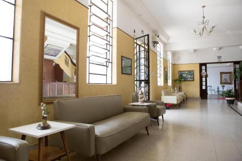 eine Lobby mit einem Sofa und Stühlen in einem Gebäude in der Unterkunft Grande Hotel Atibaia in Atibaia