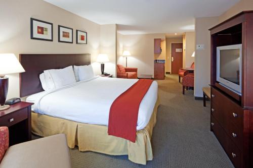 a hotel room with a large bed and a flat screen tv at Holiday Inn Express Hotel & Suites Freeport by IHG in Freeport