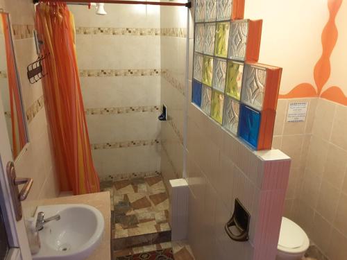 a bathroom with a sink and a toilet with stained glass windows at Hostal La Casa del Sol in Copacabana