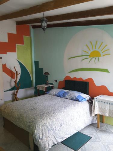 1 dormitorio con 1 cama con una pintura en la pared en Hostal La Casa del Sol, en Copacabana