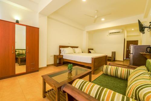 a hotel room with a bed and a living room at Chaaya inn Hotel in Hikkaduwa