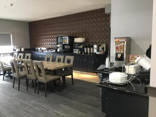a dining room with a table and chairs and a bar at Wingate by Wyndham Lethbridge in Lethbridge
