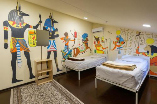 um quarto com 2 camas e uma parede com um mural em Light Hostel em Tashkent