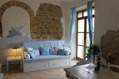 a living room with a blue couch and a brick wall at Agriturismo Carincone in Pergola