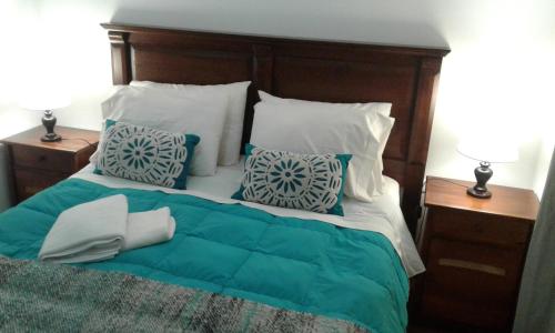 a bed with blue and white pillows on it at Casa Vesta Mar in San Antonio