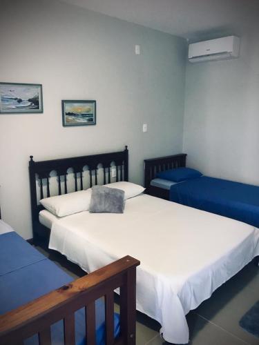 two beds in a room with blue and white at Hotel Zona Sul in São Gabriel