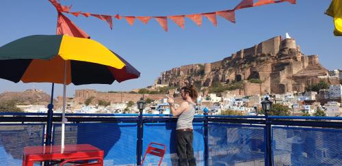 a woman standing next to a pool with a view of the acropolis at Raj Mandir Boutique Home Stay in Jodhpur