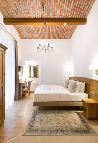 a bedroom with a bed and a wooden ceiling at Ventus Rosa Boutique Aparthotel in Kraków