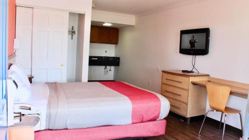 a bedroom with a bed and a desk and a television at Motel 6-Dayton, OH in Dayton