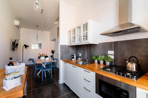 uma cozinha com armários brancos e um forno com placa de fogão em Le Stanze Di Catia em Florença