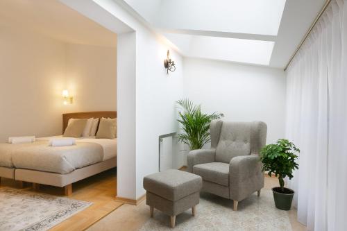 a bedroom with a bed and a chair at Ventus Rosa Boutique Aparthotel in Kraków