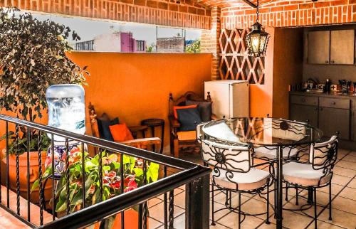 a balcony with a table and chairs and a kitchen at Casa del Sol Inn in Ajijic