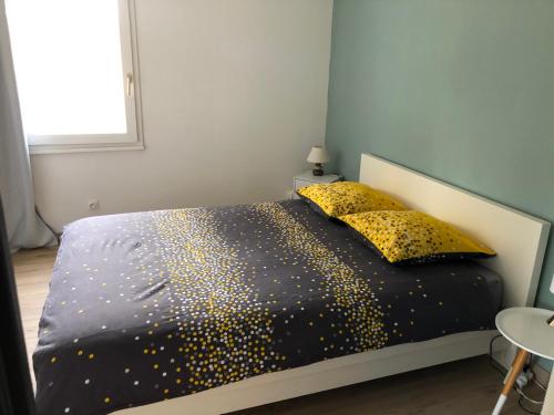 Appartement de charme idéalement situé في غاب: غرفة نوم بسرير وملاءات ووسائد سوداء وذهبية