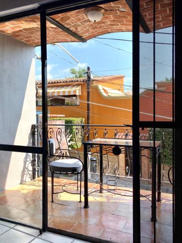 a patio with a table and a chair on a balcony at Casa del Sol Inn in Ajijic