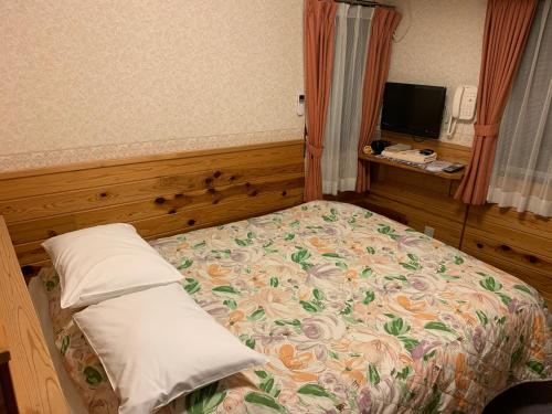 a bedroom with a bed with a floral bedspread at Turtle Inn Nikko in Nikko
