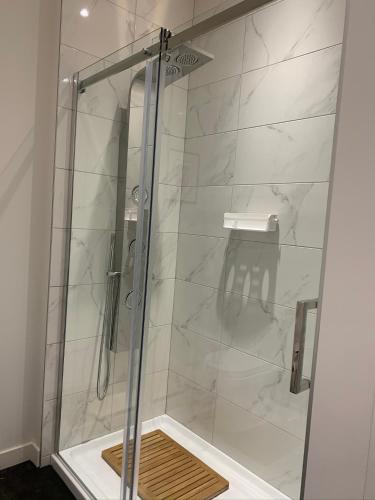 a shower with a glass door in a bathroom at La Bohème - Bed & Breakfast in Bromont
