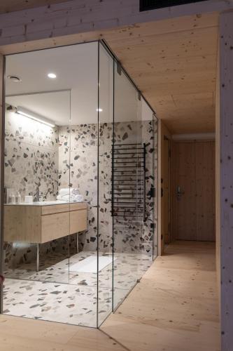a glass bathroom with a tub and a sink at Mari Pop Hotel in Ried im Zillertal