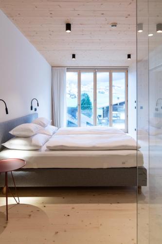 a bedroom with a large bed and a large window at Mari Pop Hotel in Ried im Zillertal
